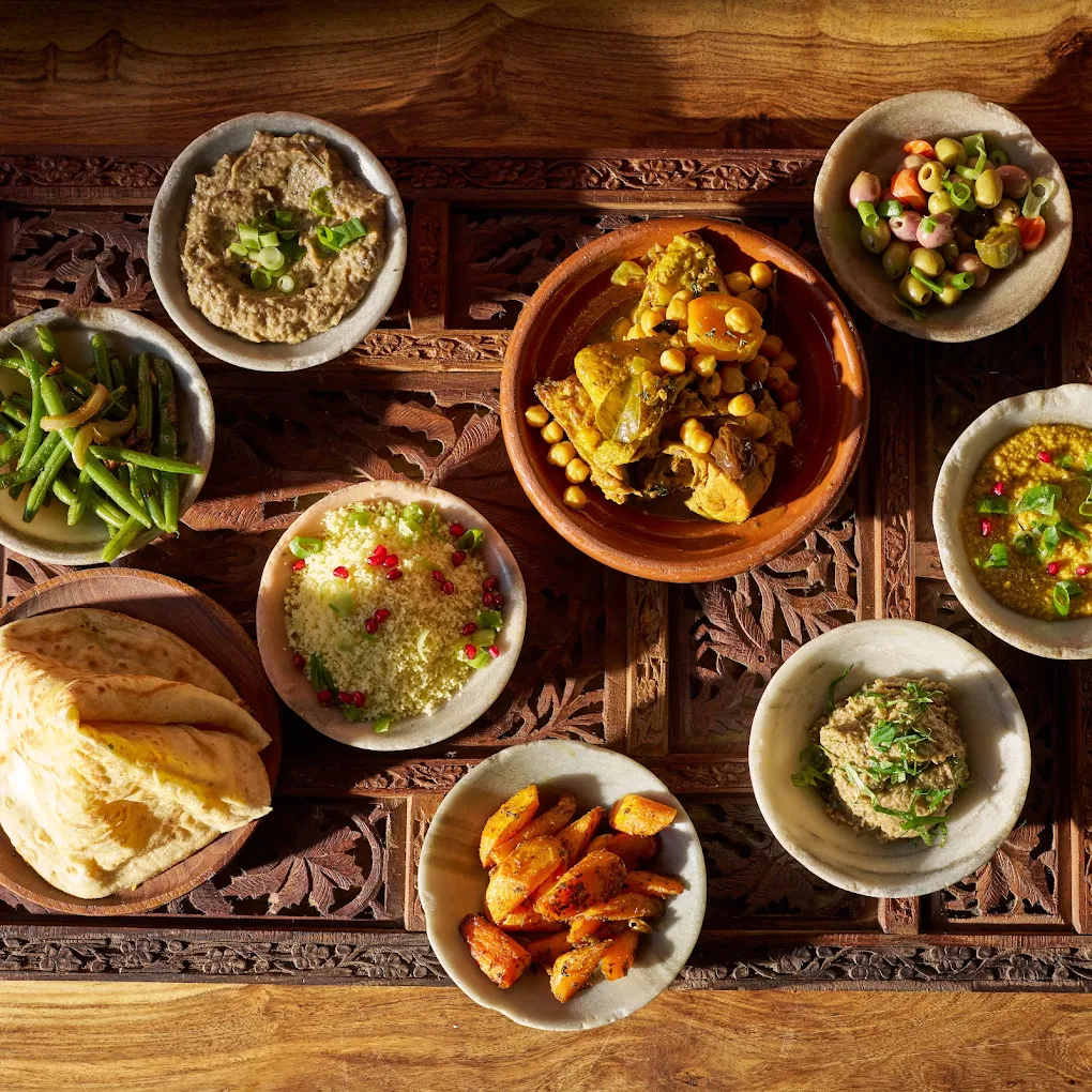 Table of RAÏNARAÏ mezze: couscous, zaalouk, olives, flatbread and tagine