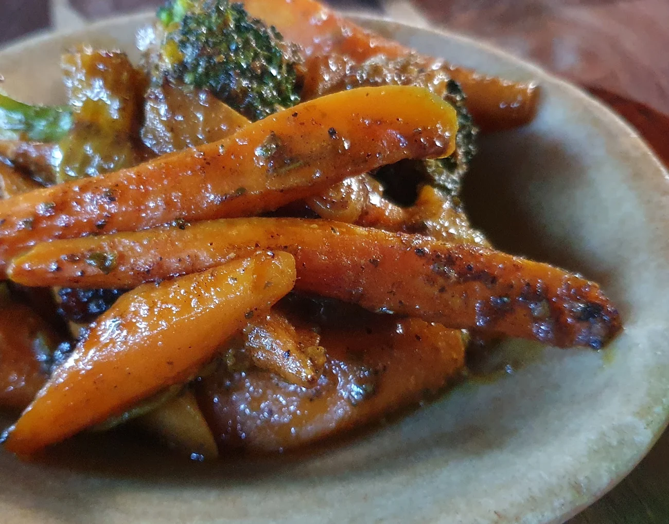 Glazed spiced carrots with broccoli in a stone bowl